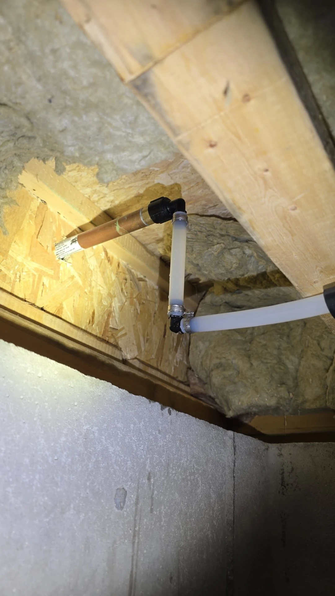 New PEX water line transitioning to existing copper pipe in a basement ceiling