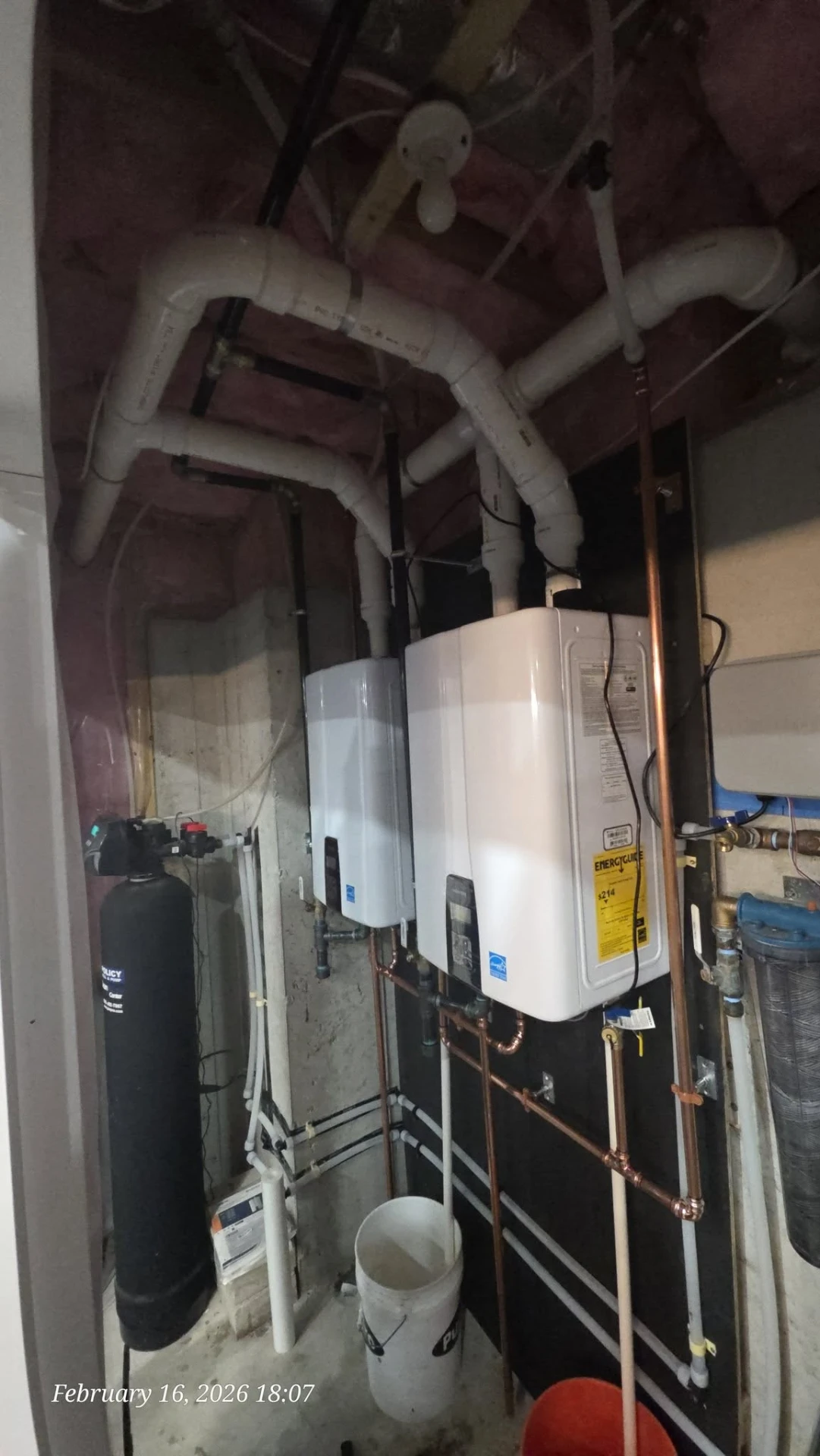 Tankless water heaters, whole-home filter tank and copper venting in a finished mechanical room